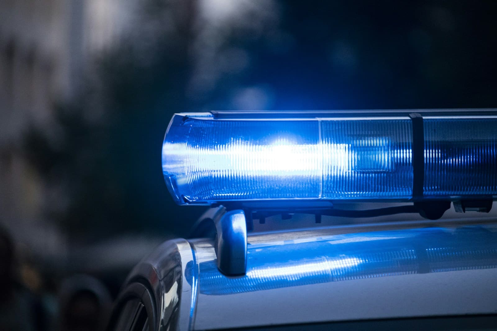 Blue police car emergency lights flashing on patrol vehicle roof
