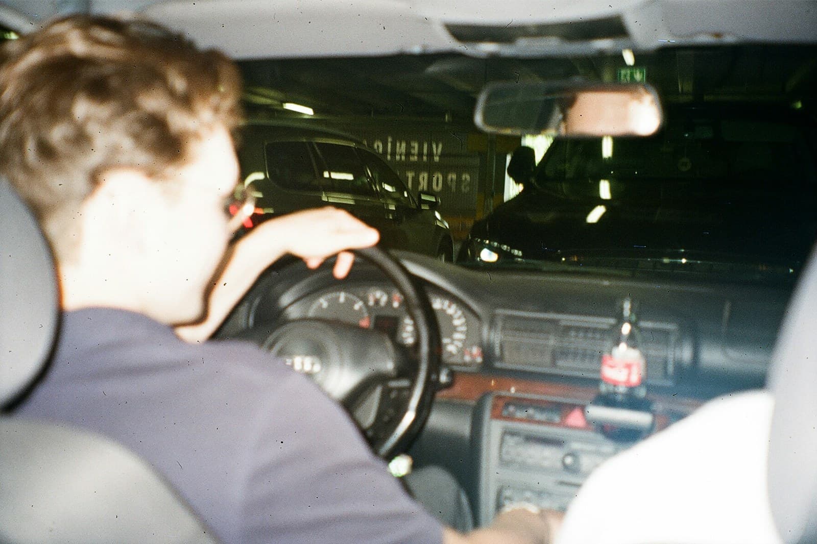 Driver with curly blonde hair at the wheel at night, dashboard lights glowing