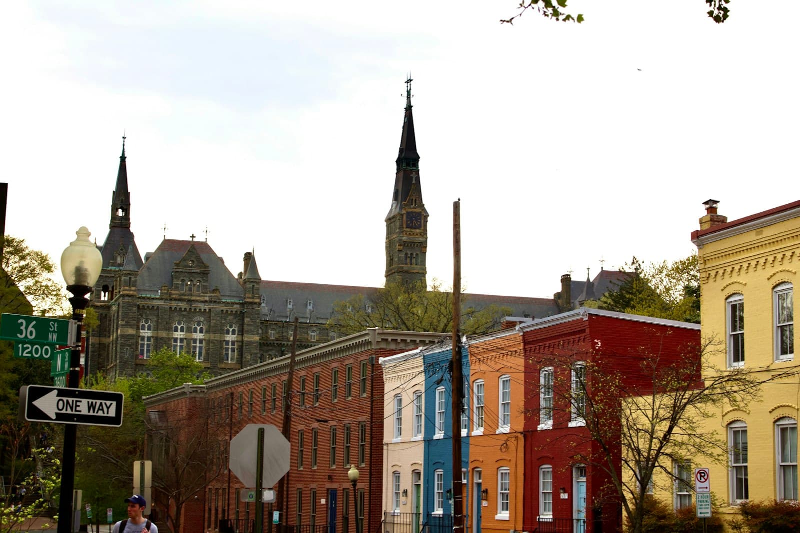 Colorful historic row houses on city street with Gothic church spires visible in background