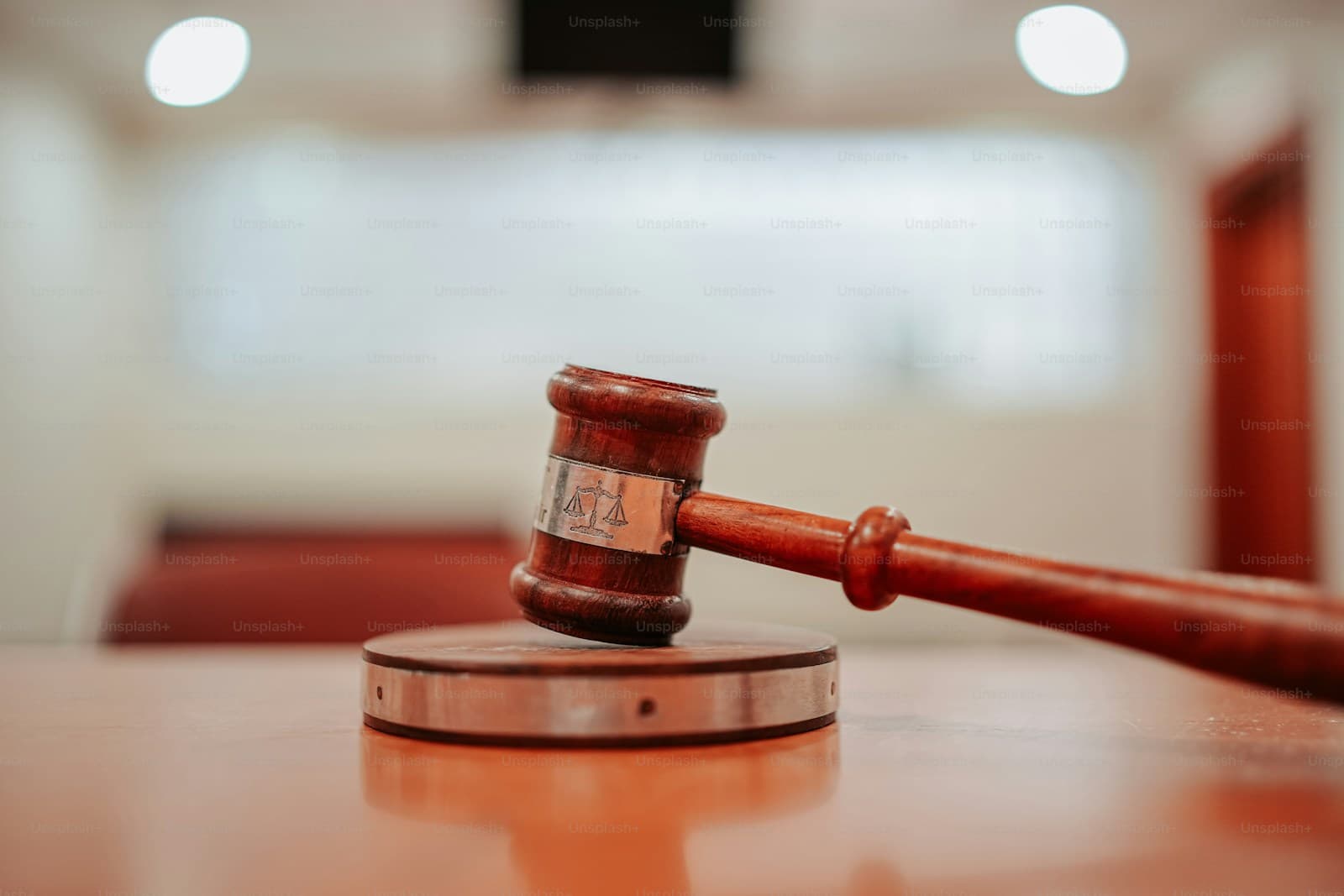Wooden judge's gavel on sound block in courtroom setting with blurred background